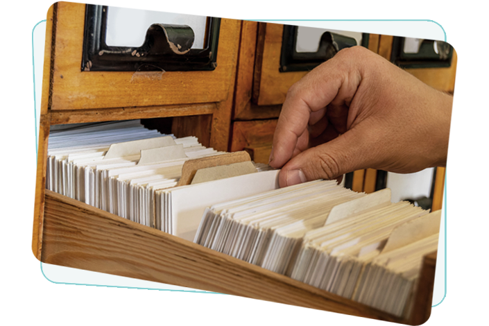 Main parcourant des fiches dans un placard